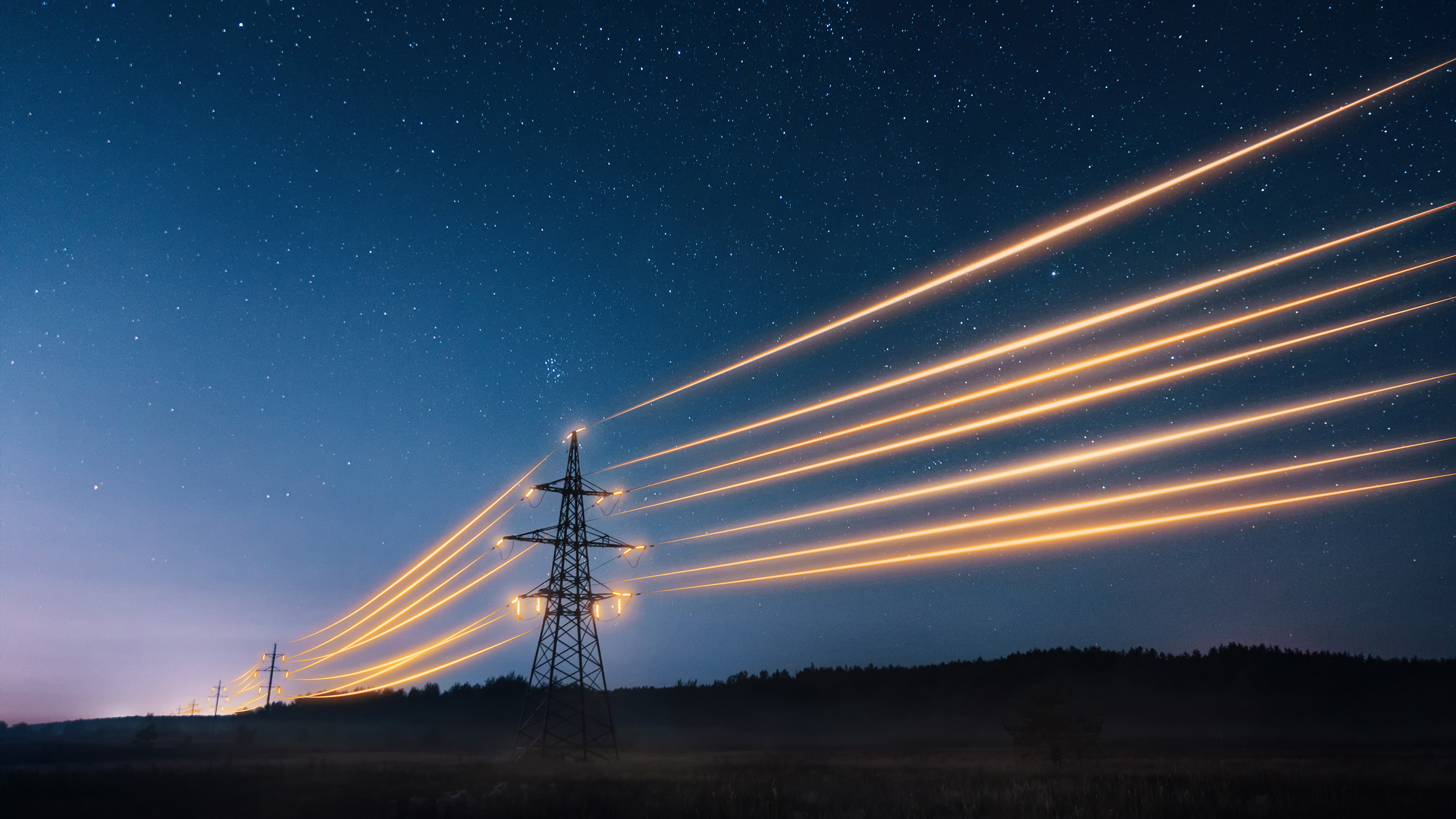 landscape image of glowing electrical wires against a starry night sky