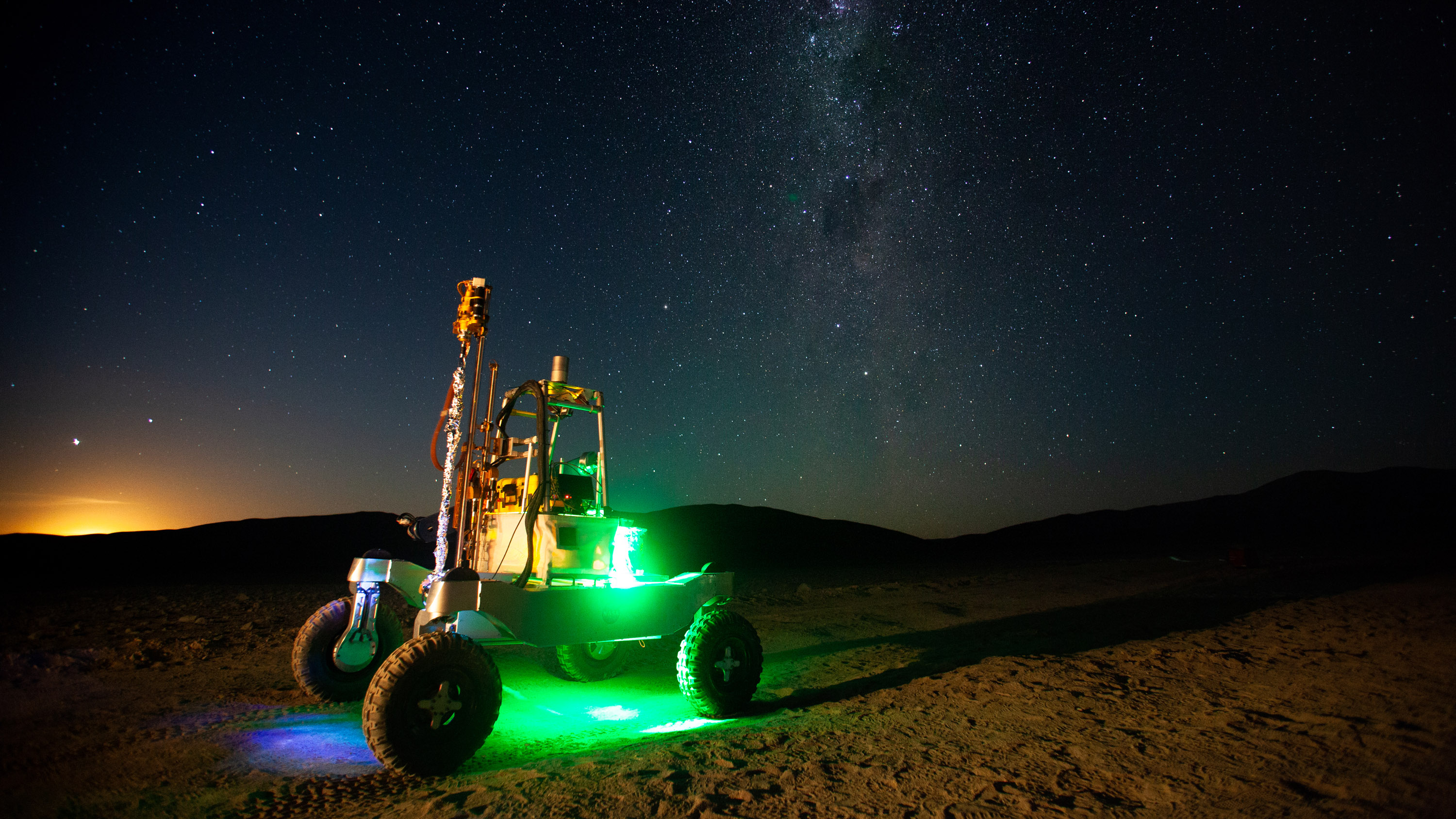 ARADS rover glowing with green light in under a starry sky