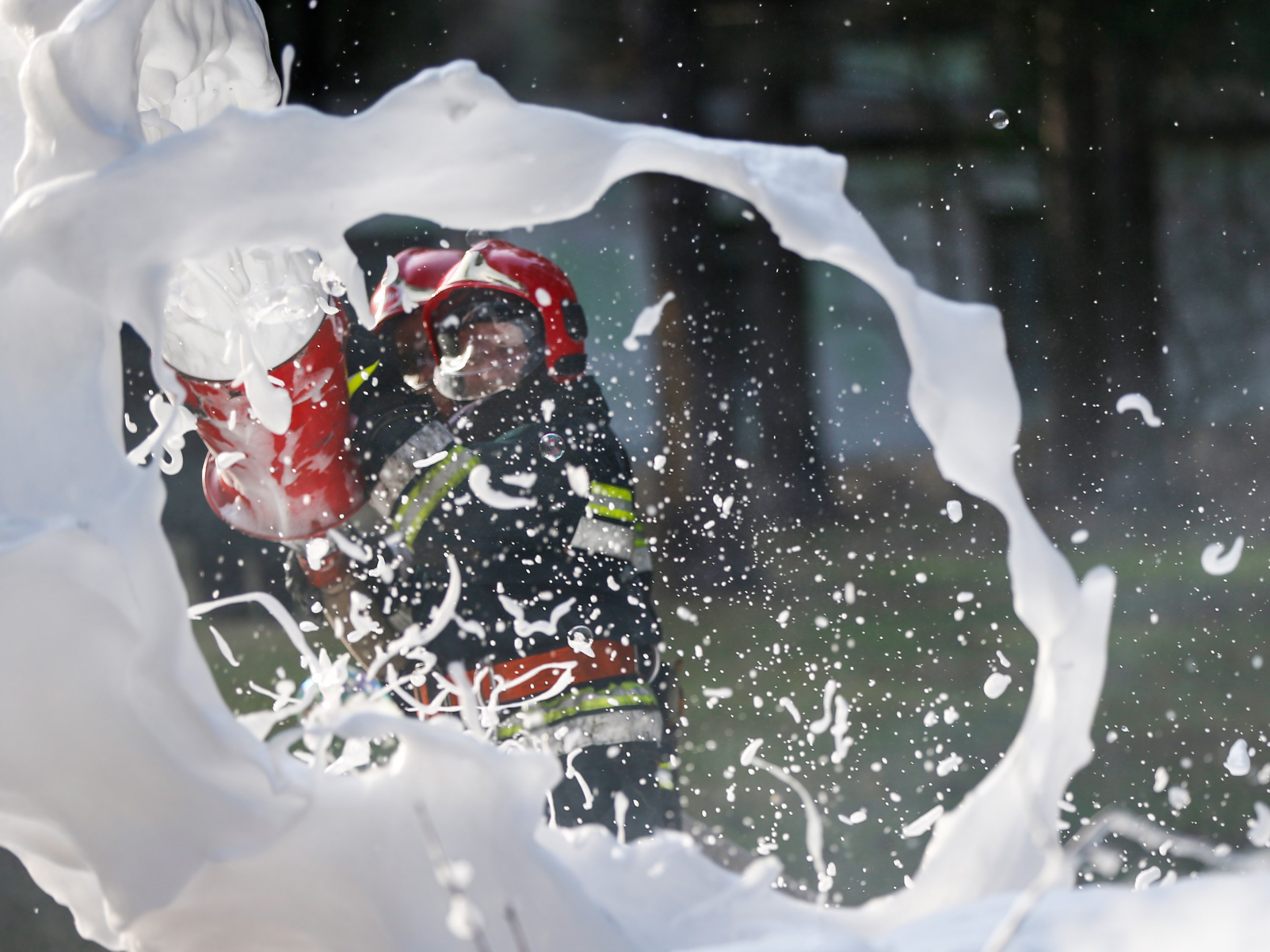 foam from a firefighter's extinguisher spraying toward the camera