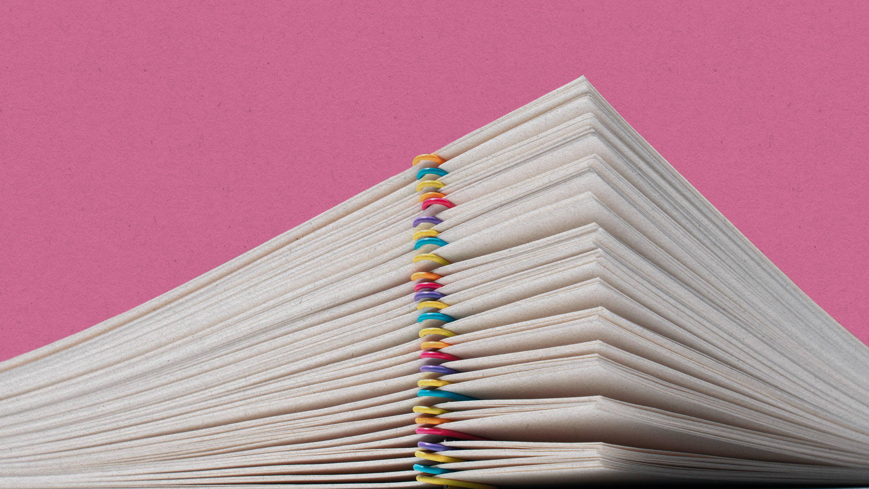 macro view of a sheaf of paper with colored paperclips forming a peak