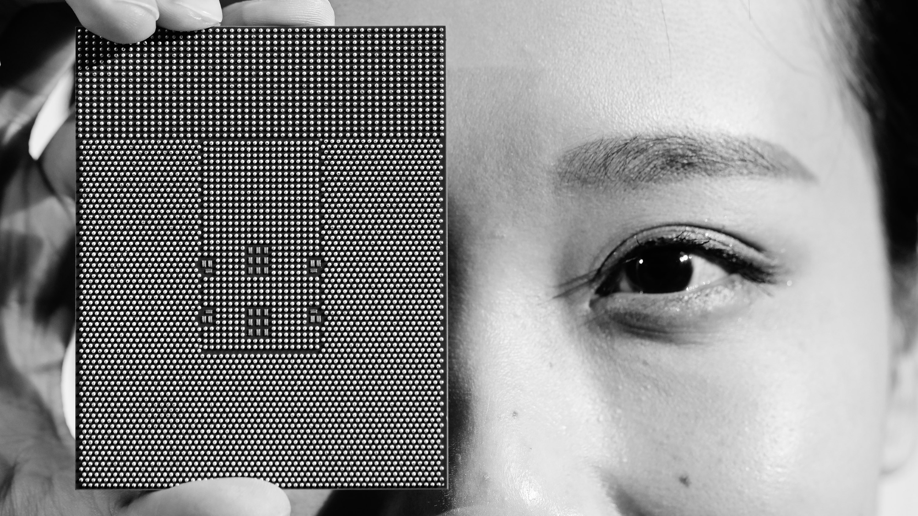 closeup photo of a Kungpeng 920 chip and a face with the chip held over one eye.