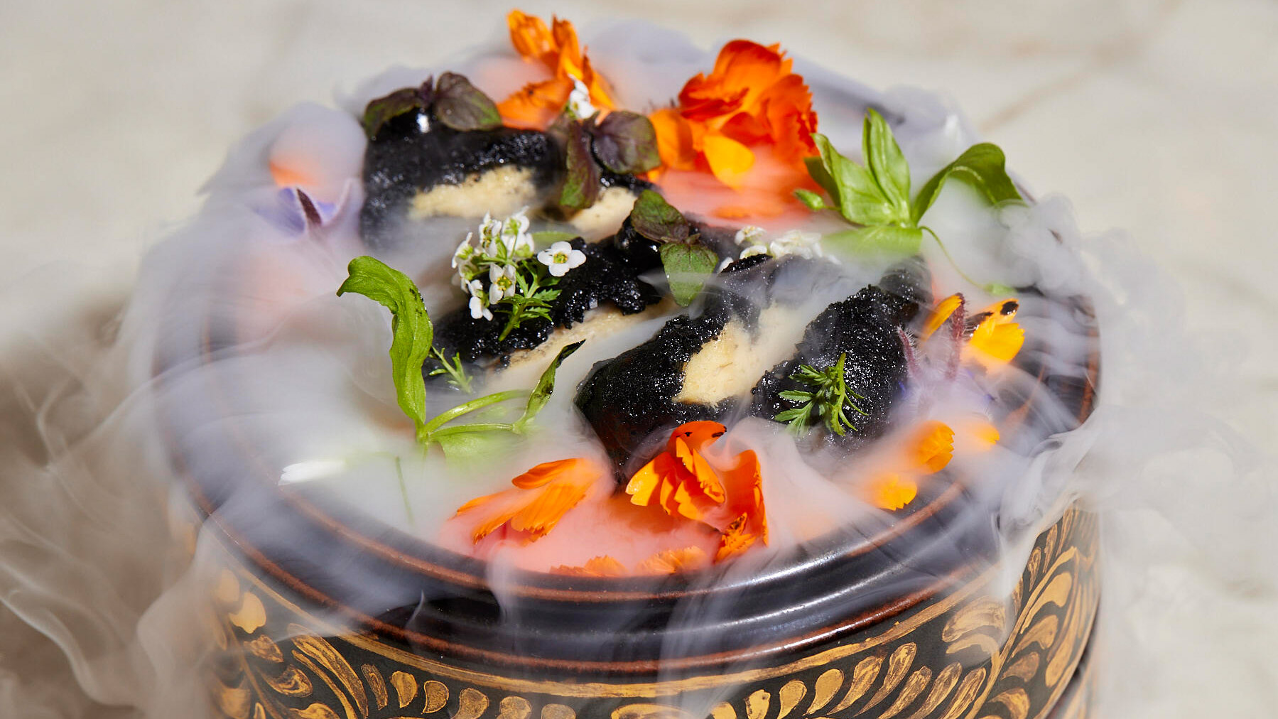 a steamy dish of cultivated chicken garnished with edible flowers