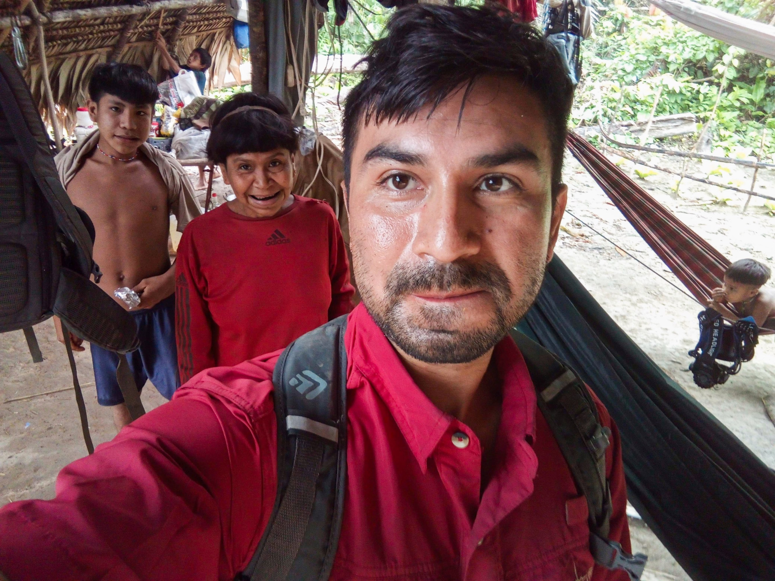 David taking a selfie with his mother and another young villager from inside a Yanomami dwelling