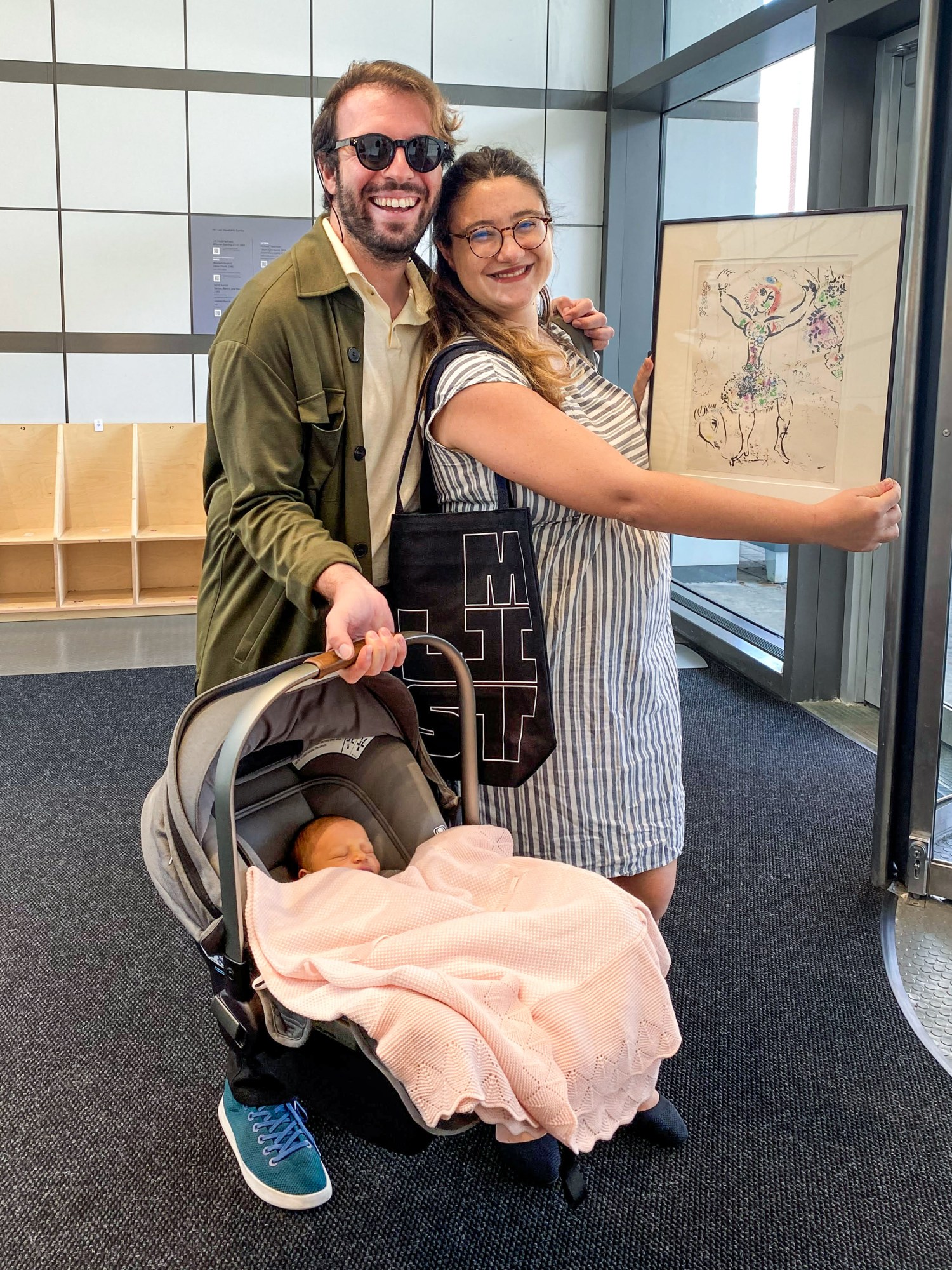 Carmelo Ignaccolo and his wife and infant hold up a framed work of art