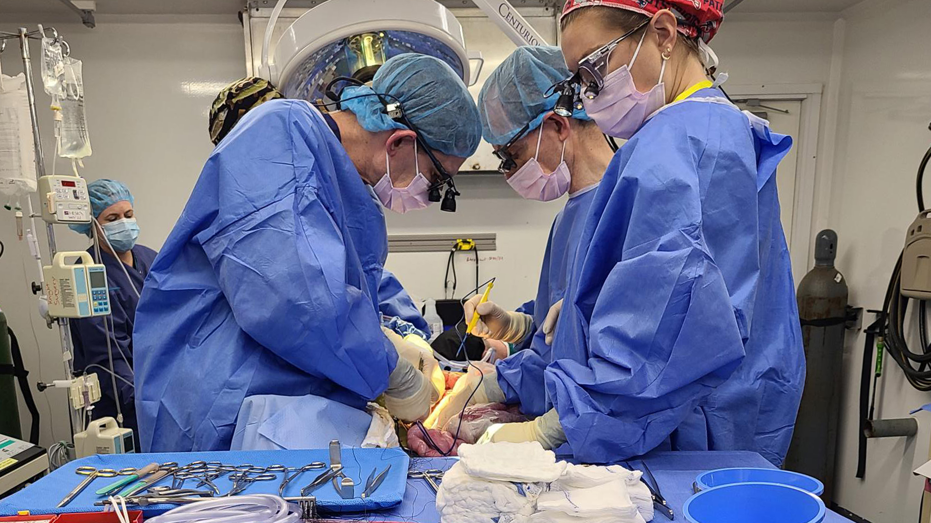 Four surgeons hovered over an operating table.