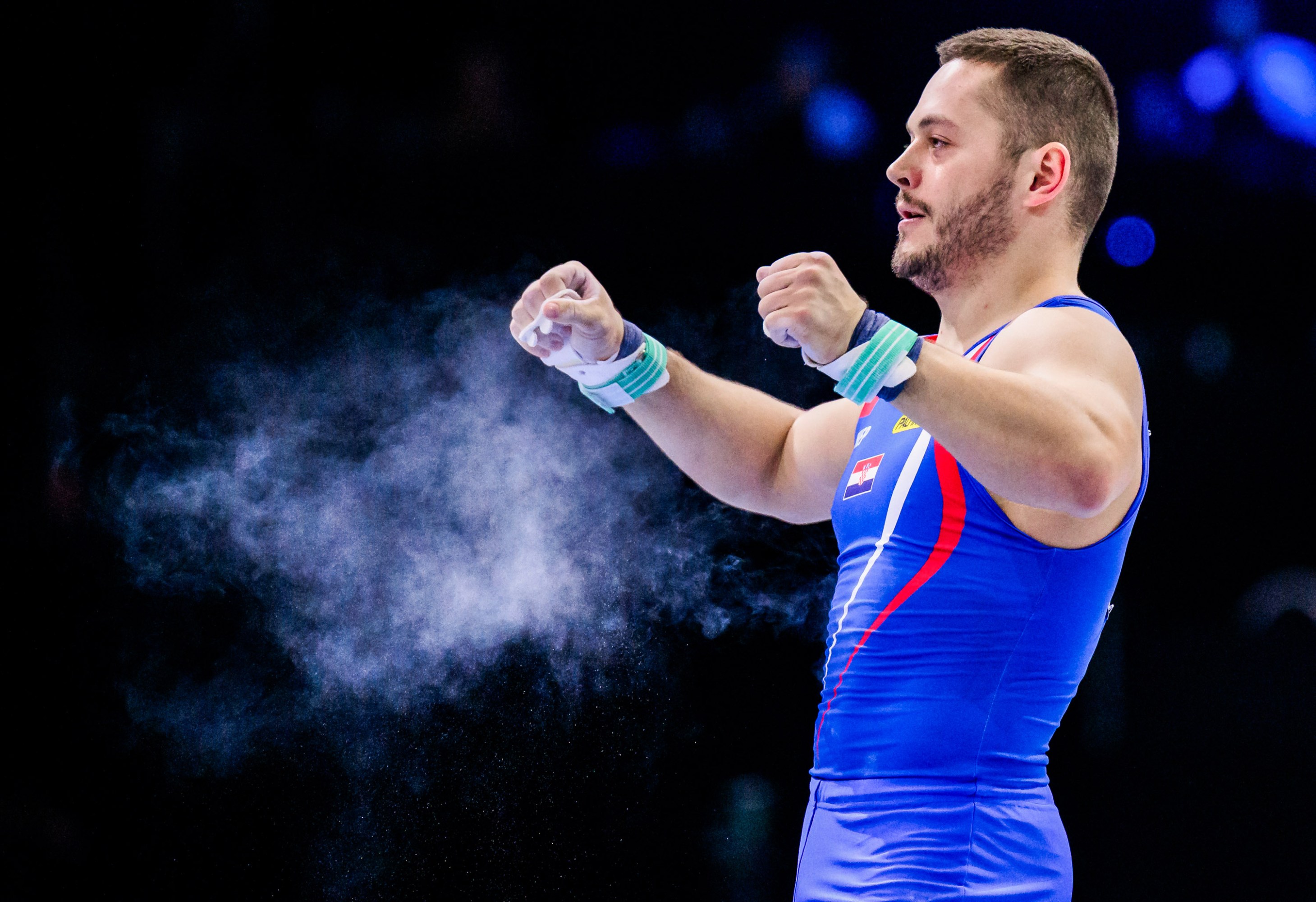 Tin Srbic pumping his arms, which has produced a cloud of chalk dust in the arm in front of him