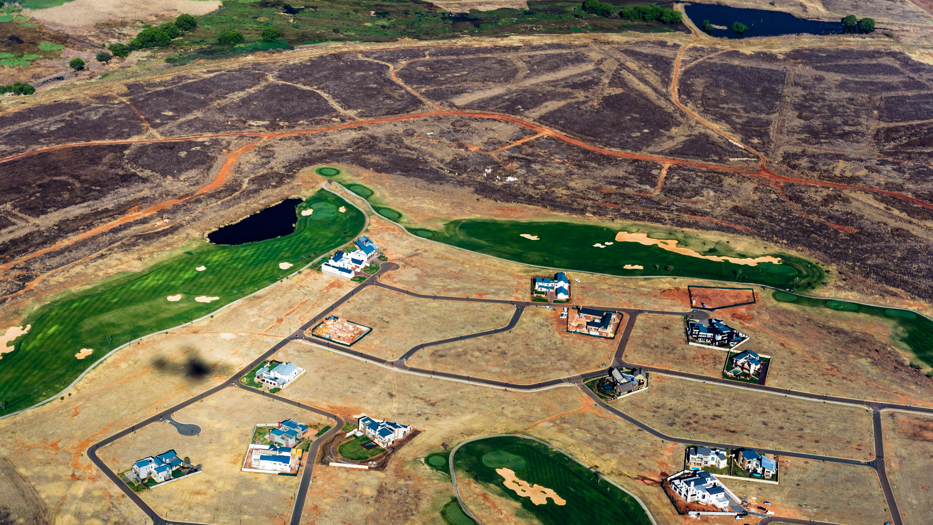 aerial view of a residential housing compounds surrounded by patches of undeveloped land in Gauteng Province