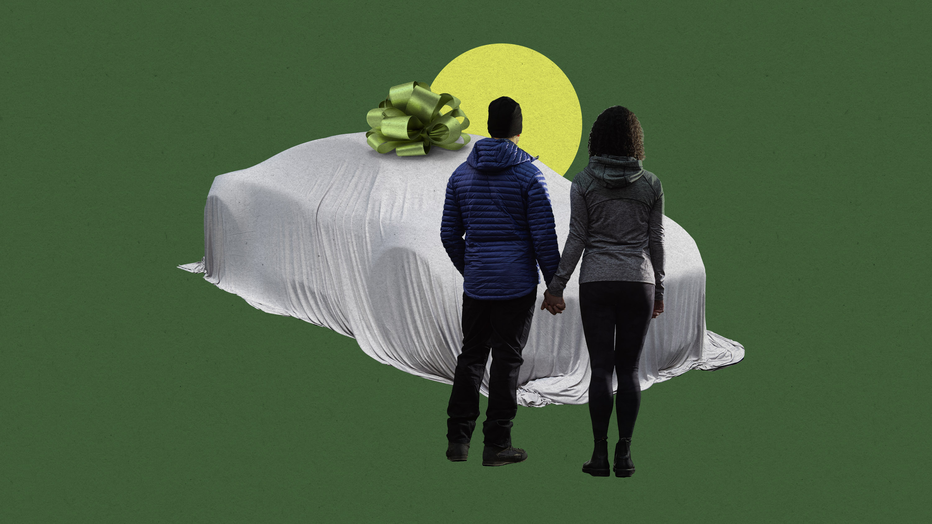 a couple stands looking at a car under a cloth with a green bow on it