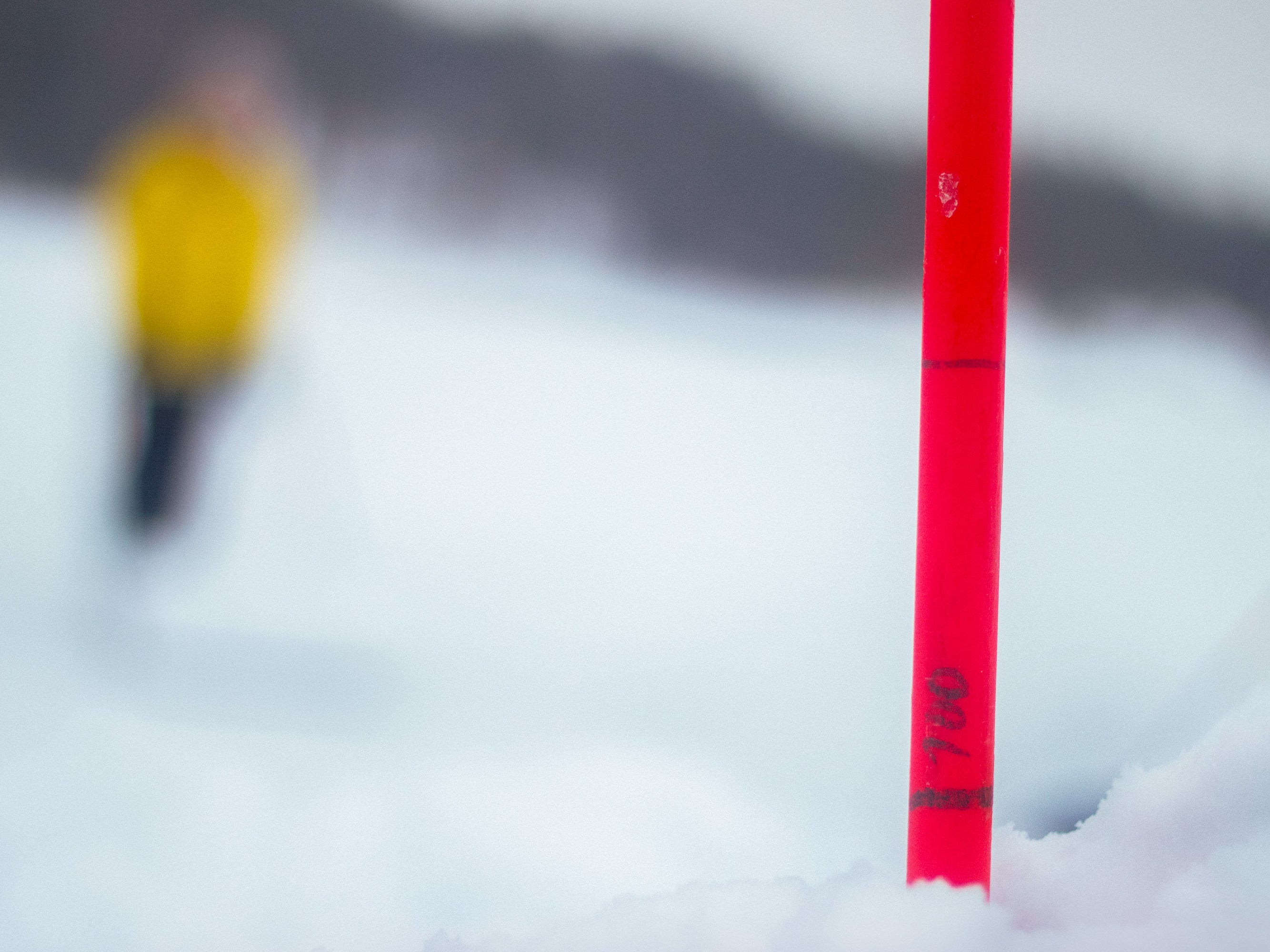 close-up of a florescent stick, marked with numbers in the snow