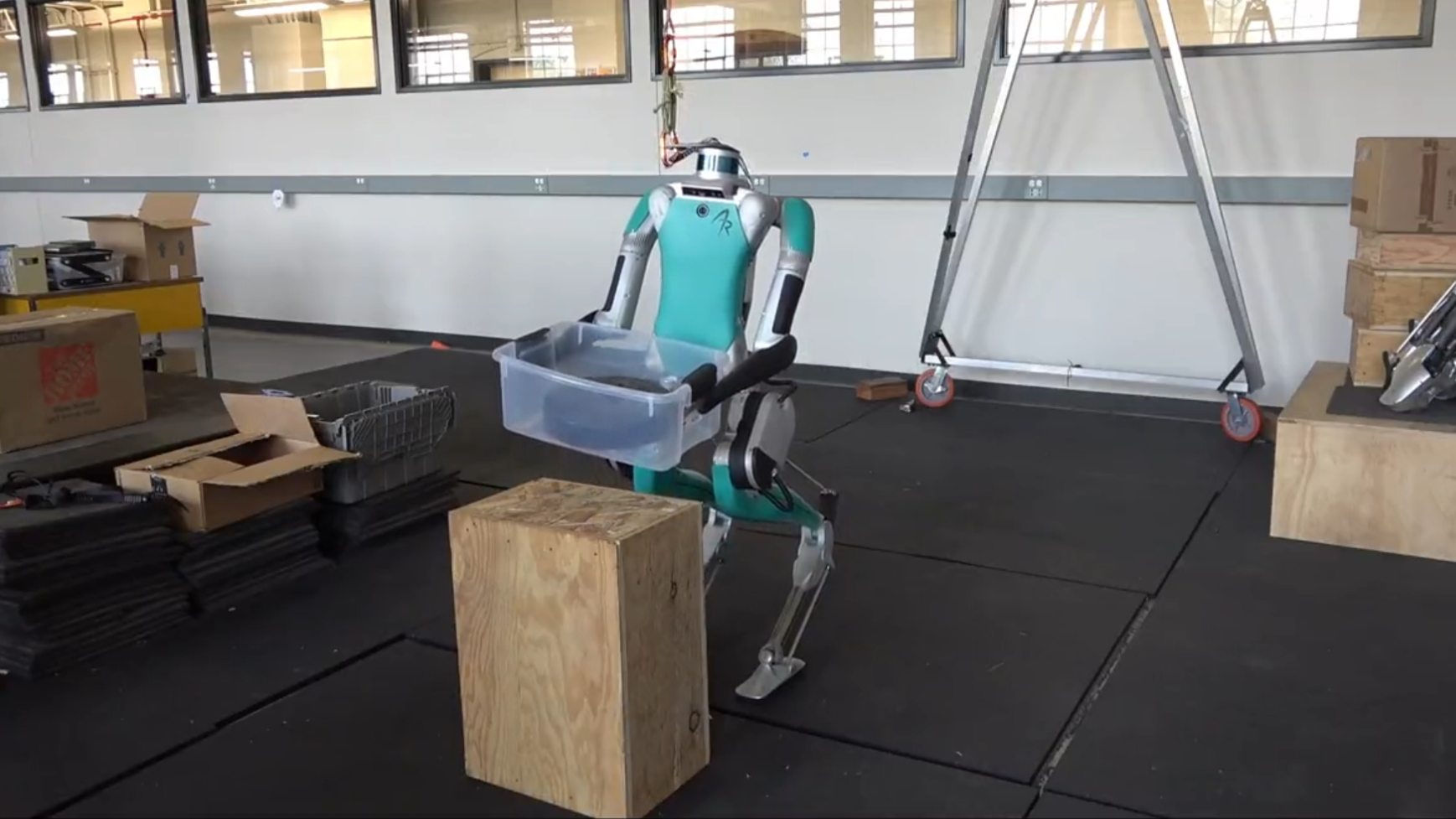 Digit humanoid robot picking up a plastic tote