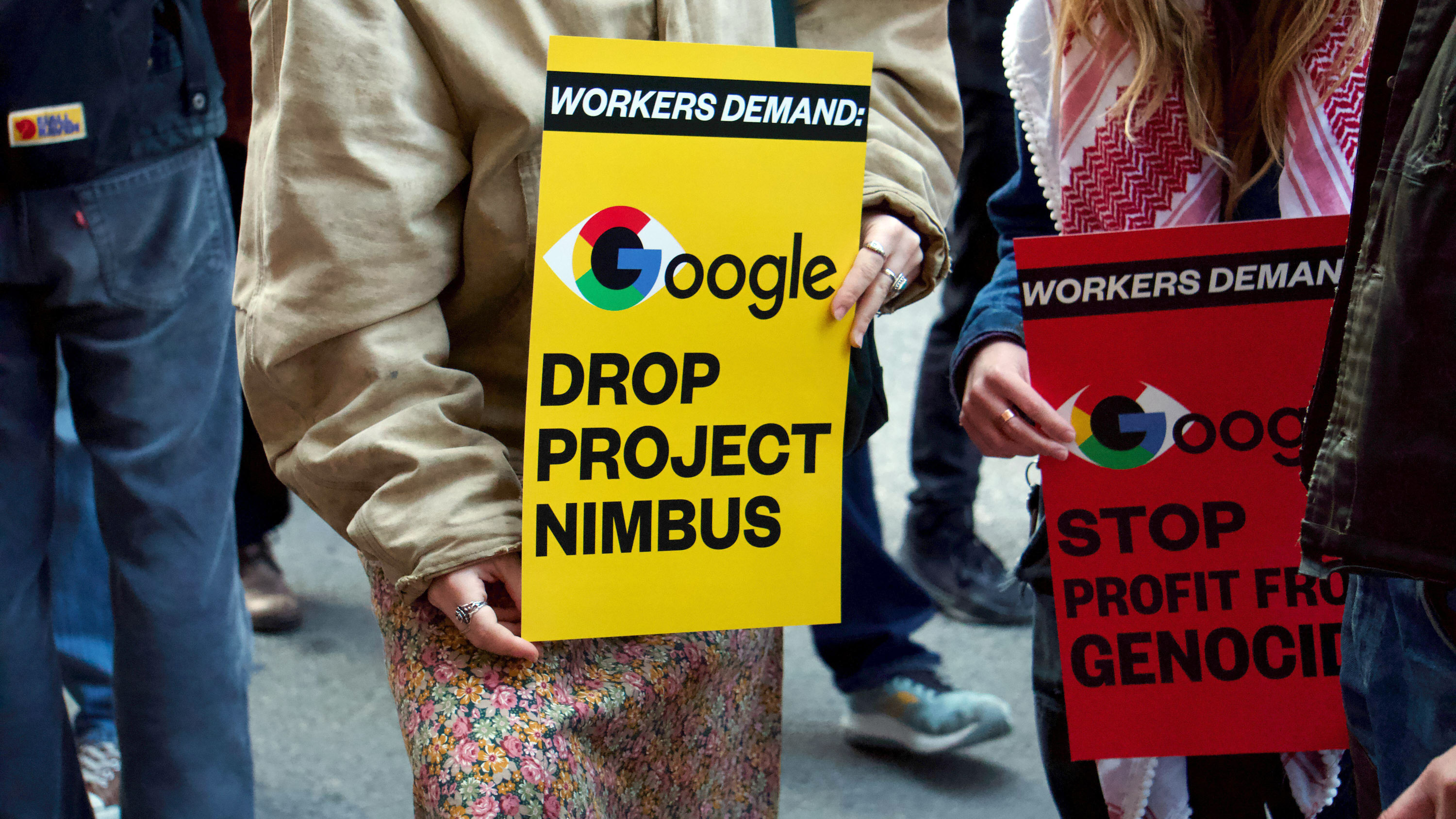 Low shot of two signs held at waist level which read, &quot;Workers Demand: Google drop Project Nimbus&quot; and &quot;Workers Demand: Google stop profit from genocide&quot;