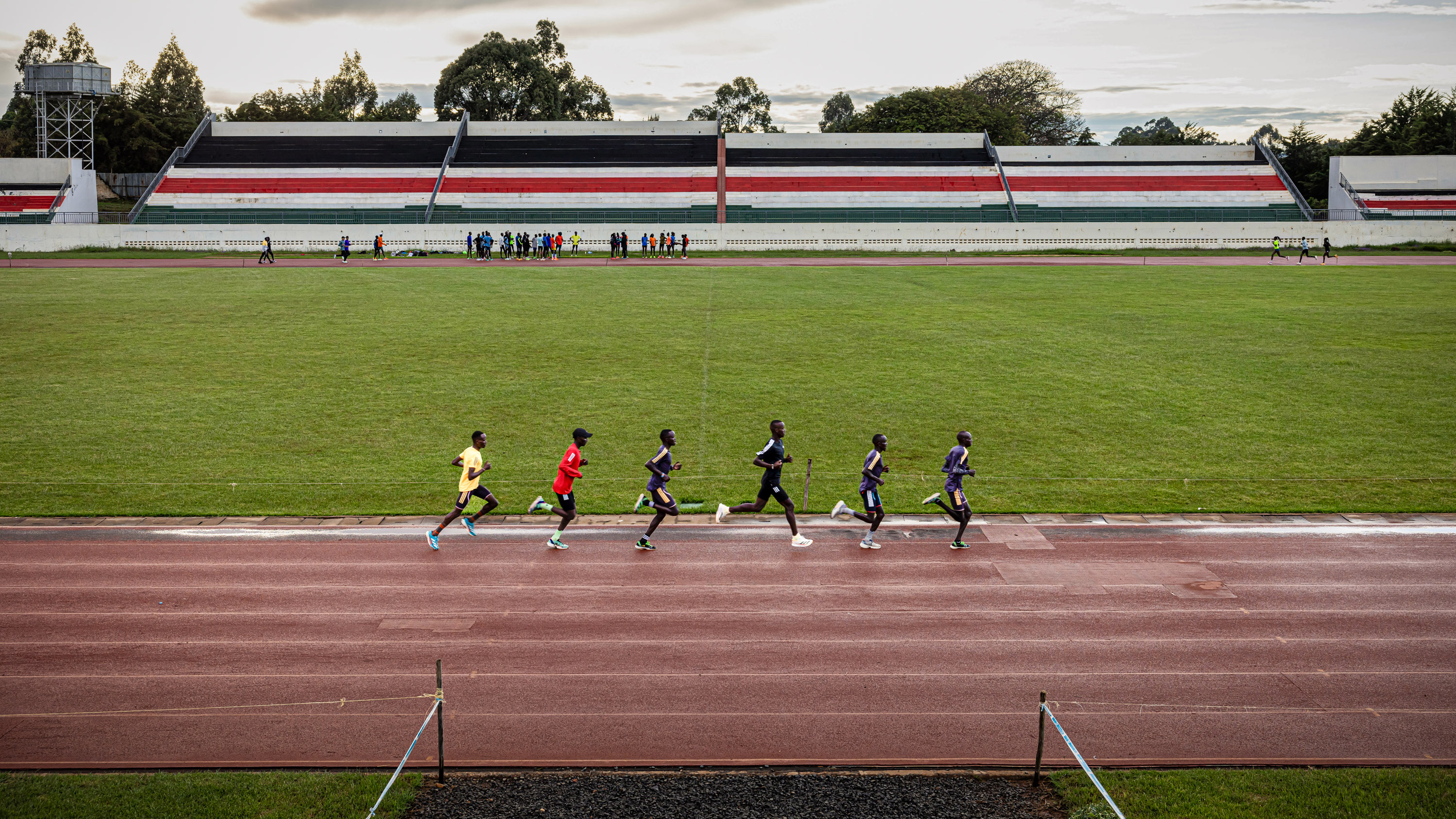 six runners running in a line on a track