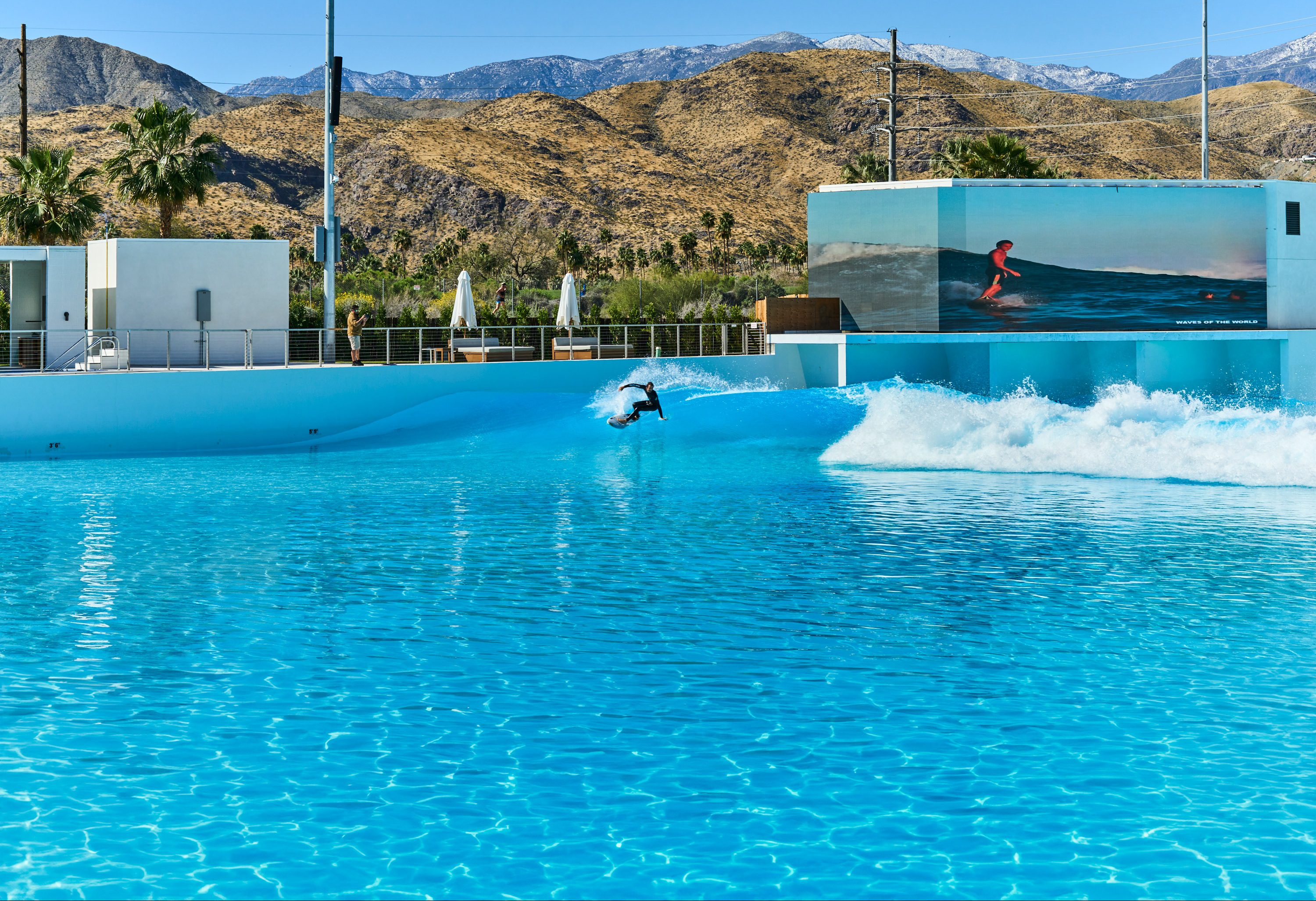 a surfer riding a wave in the pool at the Palm Springs Surf Club